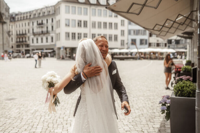 Braut trifft auf Brautvater, der sie voller Freude in die Arme schliesst.