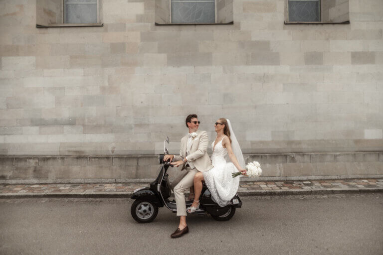 Brautpaar fährt mit einer Vespa durch den Münsterhof in Zürich und ist sehr erfreut